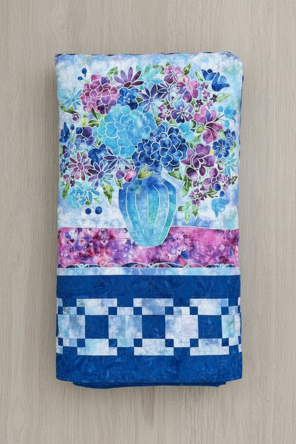 Elegant handmade floral quilt with blue and purple flowers and hummingbird accents.