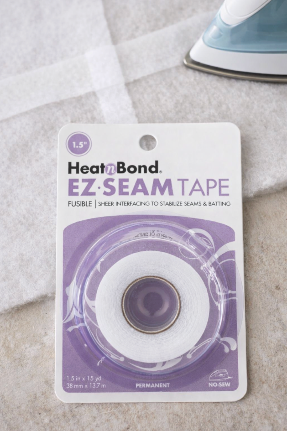 Quilting essentials flat lay with HeatnBond EZ-Steam batting tape and iron for clean, professional quilt finishes