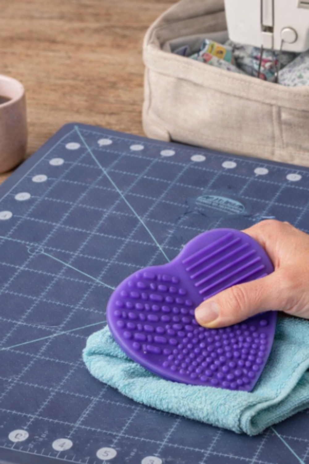 Cleaning a self-healing rotary cutting mat using a soft cloth and silicone scrubber to remove lint and restore cutting surface