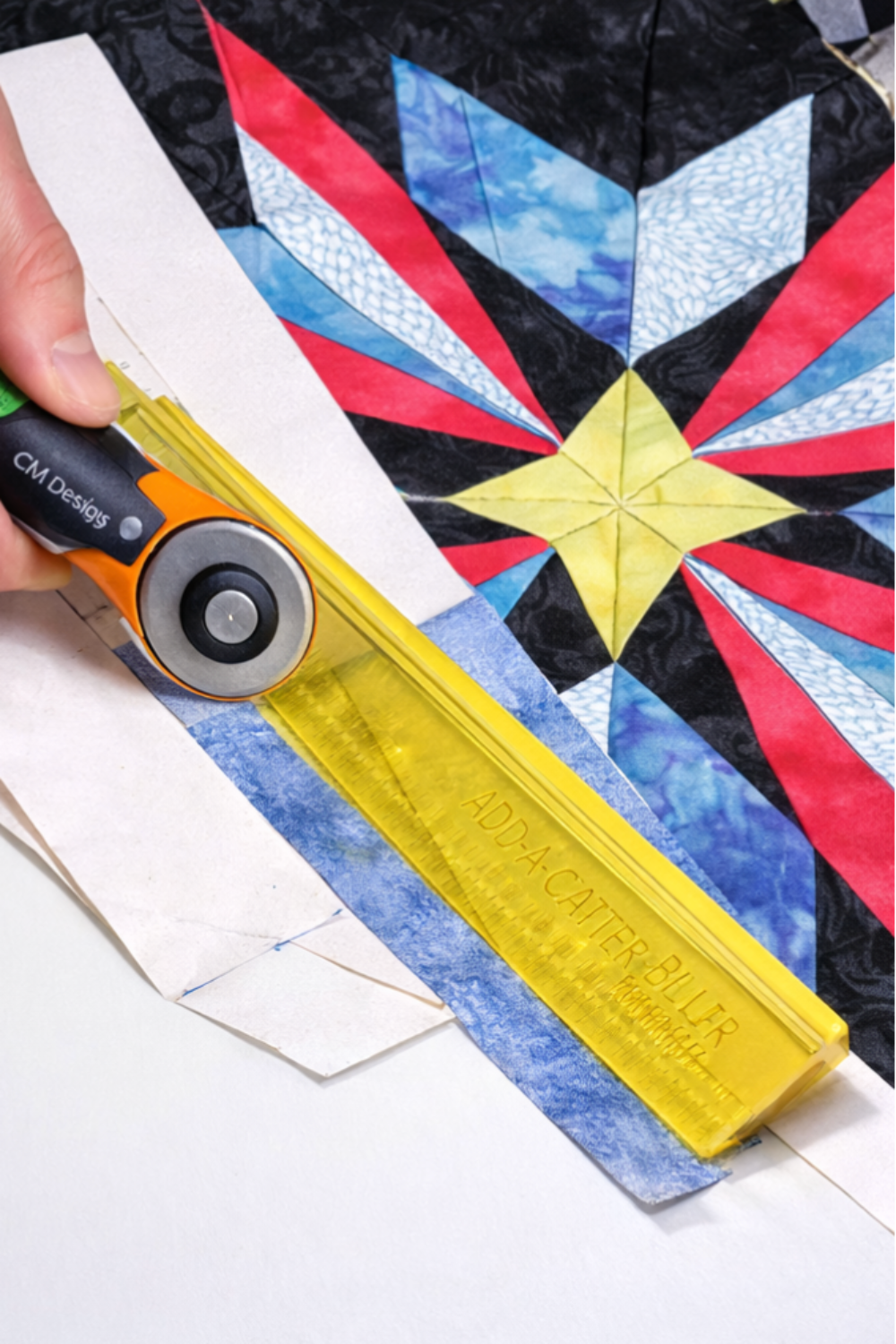Using Add-A-Quarter Plus ruler with rotary cutter to trim foundation paper pieced star quilt block