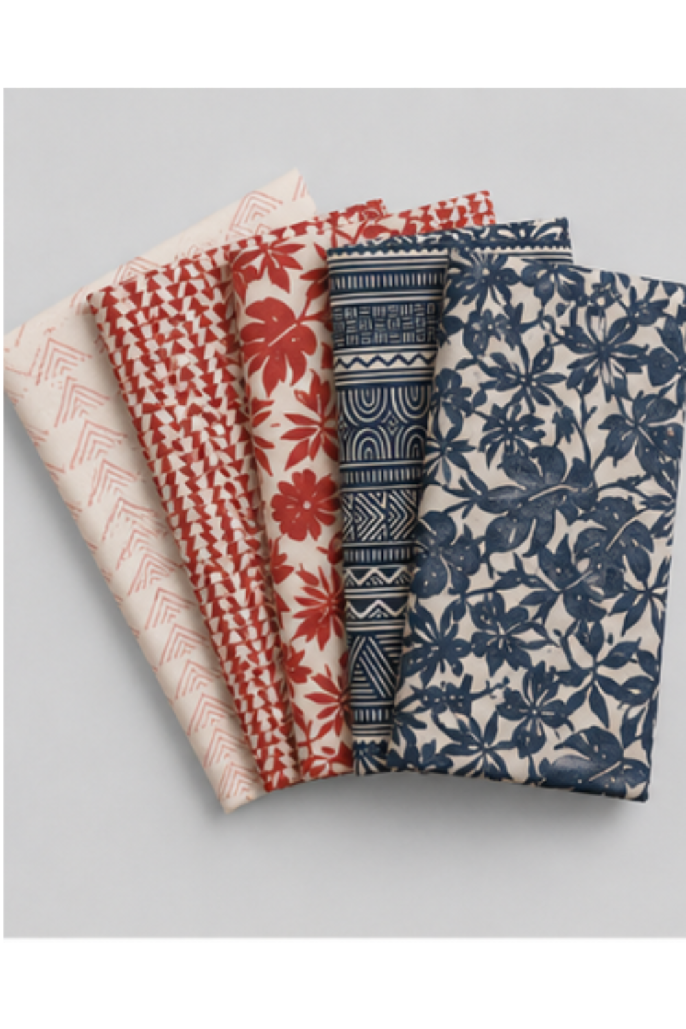 Coordinating Breezeway fabric cuts arranged together, including Blue/Cream Textured Palms, navy geometric prints, and cream-and-blue triangle and palm designs.