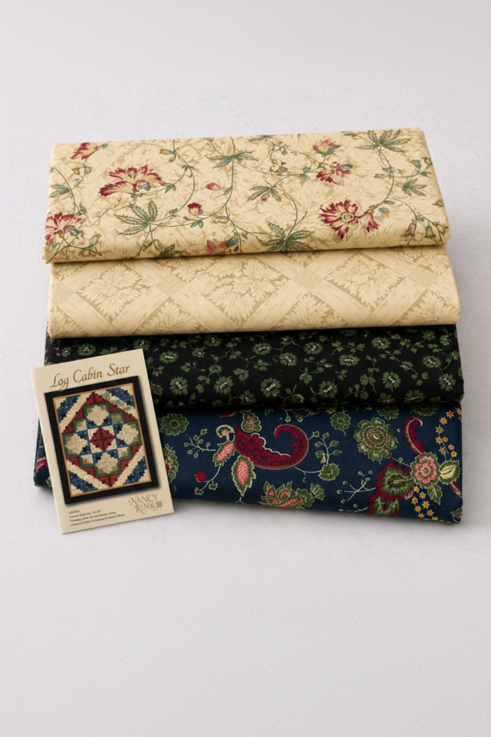 Vintage Charm by Judie Rothermel for Marcus Fabrics – 4-fabric reproduction quilt coordination stack featuring cream floral vine, cream lattice, black green ditsy floral, and navy paisley cottons with Log Cabin Star quilt pattern by Nancy Rink