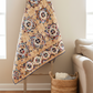 Scrappy Trail Mix quilt draped indoors highlighting warm neutrals and detailed quilting