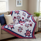 Red, white, and blue star-patterned quilt draped over a beige sofa in a living room.