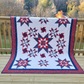 Handmade twin full star quilt draped over railing with autumn landscape backdrop