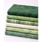 Expressions Batiks Hand-Dyes Evergreen fabric by Riley Blake Designs on top of a coordinating stack of green quilting cotton fabrics in a range of shades from deep forest green to soft sage, light plaid, cream with sage dots, and medium botanical green – rich deep forest green hand-dyed batik with organic mottled texture, 100% cotton batik