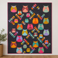 Thatched Shadow deep purple fabric by Robin Pickens for Moda Fabrics shown as quilt background. Quilts shown for inspiration feature the Mod Owls Revival Quilt Pattern by Sew Kind of Wonderful — available at IraRobi Quilts.