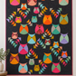 Thatched Shadow deep purple fabric by Robin Pickens for Moda Fabrics shown as quilt background. Quilts shown for inspiration feature the Mod Owls Revival Quilt Pattern by Sew Kind of Wonderful — available at IraRobi Quilts.