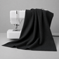 Texture Graphix Speckle Black quilting cotton fabric draped over a sewing machine – deep charcoal-black tonal speckled blender by Jason Yenter for In The Beginning Fabrics, 100% cotton