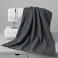 Spotted Charcoal quilting cotton fabric draped over a sewing machine – deep charcoal-grey tonal speckled near-solid blender by Zen Chic for Moda Fabrics, 100% cotton