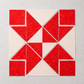 Double Pinwheel quilt block layout featuring Expressions Batiks Hand-Dyes Tomato Red fabric by Riley Blake Designs – bold vivid tomato red tonal hand-dyed batik triangles and squares paired with crisp white-on-white red polka dot fabric in a dynamic pinwheel arrangement on a light grey surface. Quilt blocks shown for inspiration. Coordinating fabrics and quilt patterns are available at IraRobi Quilts.