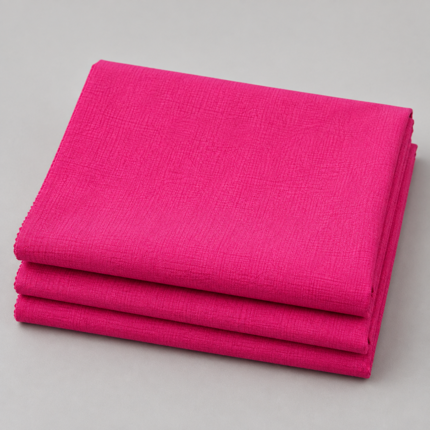 Thatched Fuchsia quilting cotton fabric by Robin Pickens for Moda Fabrics neatly folded in a stack showing the vibrant fuchsia-hot pink tonal crosshatch texture. 100% cotton, 43–44" wide. Available at IraRobi Quilts.