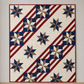 Quilt shown for inspiration features the Fifty Nifty Quilt Pattern by Shadow Valley Quilts made with Thatched Navy fabric by Robin Pickens for Moda Fabrics — navy star blocks with red diagonal stripes on a cream background. Coordinating fabrics and quilt patterns available at IraRobi Quilts.