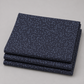 Dotty Thatched Indigo quilting cotton fabric by Robin Pickens for Moda Fabrics neatly folded in a stack on a light grey background showing the deep indigo-charcoal ground with scattered tonal grey dots. 100% cotton, 43–44" wide. Available at IraRobi Quilts.