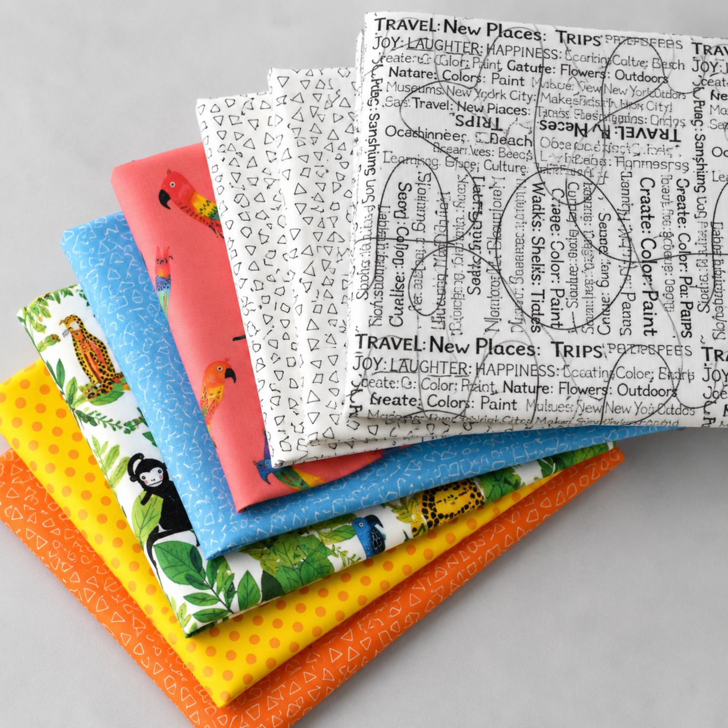 Safari Fun by Terry Runyan for Benartex — coordinating quilting fabric collection fanned stack showing jungle animals, tropical leaves, parrots, triangles, and text prints