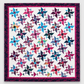 Triangles Galore finished quilt by Studio 180 Design — scrappy spinning triangle blocks in four sizes using pink, teal, blue, purple, and multicolor batiks on white background with raspberry inner border and dark navy floral outer border — twin size 68½″×97″ made with Tucker Trimmer III tool