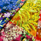Wild Blossoms Rainbow quilting cotton by Robin Pickens for Moda Fabrics — single yard of fabric folded to show multiple colorways of the rainbow ombré print including blue bluebells, chartreuse yellow goldenrod, magenta wildflowers, and red poppies — available at IraRobi Quilts