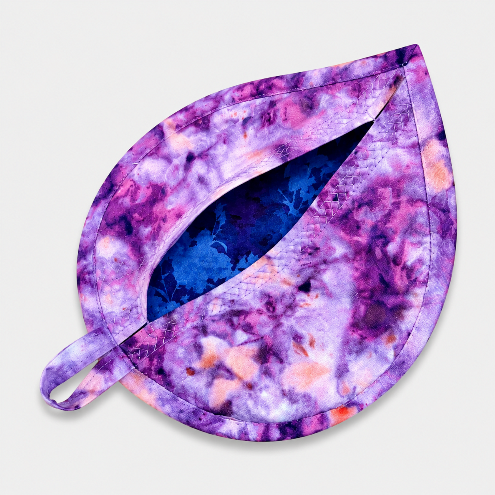 Leaf-Shaped Quilted Hot Pad – Violet Bloom, pocket open showing vivid cobalt blue floral batik lining inside, with purple, pink, and peach abstract watercolor marbled batik back and crosshatch quilting detail – handmade by IraRobi Quilts