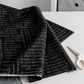 Writing on the Wall Curves Black quilting cotton folded with a drape on a white surface with scissors and cutting mat – Sew Kind of Wonderful for FreeSpirit Fabrics