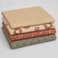 Coordinating quilting cottons from The Fox Homestead collection by Stacy West for Henry Glass — stacked folds of cream paisley swirl, cream daisy clusters, dusty rose leaf-and-berry sprigs, and slate blue-green tumbling cubes, 100% cotton 43–44" wide