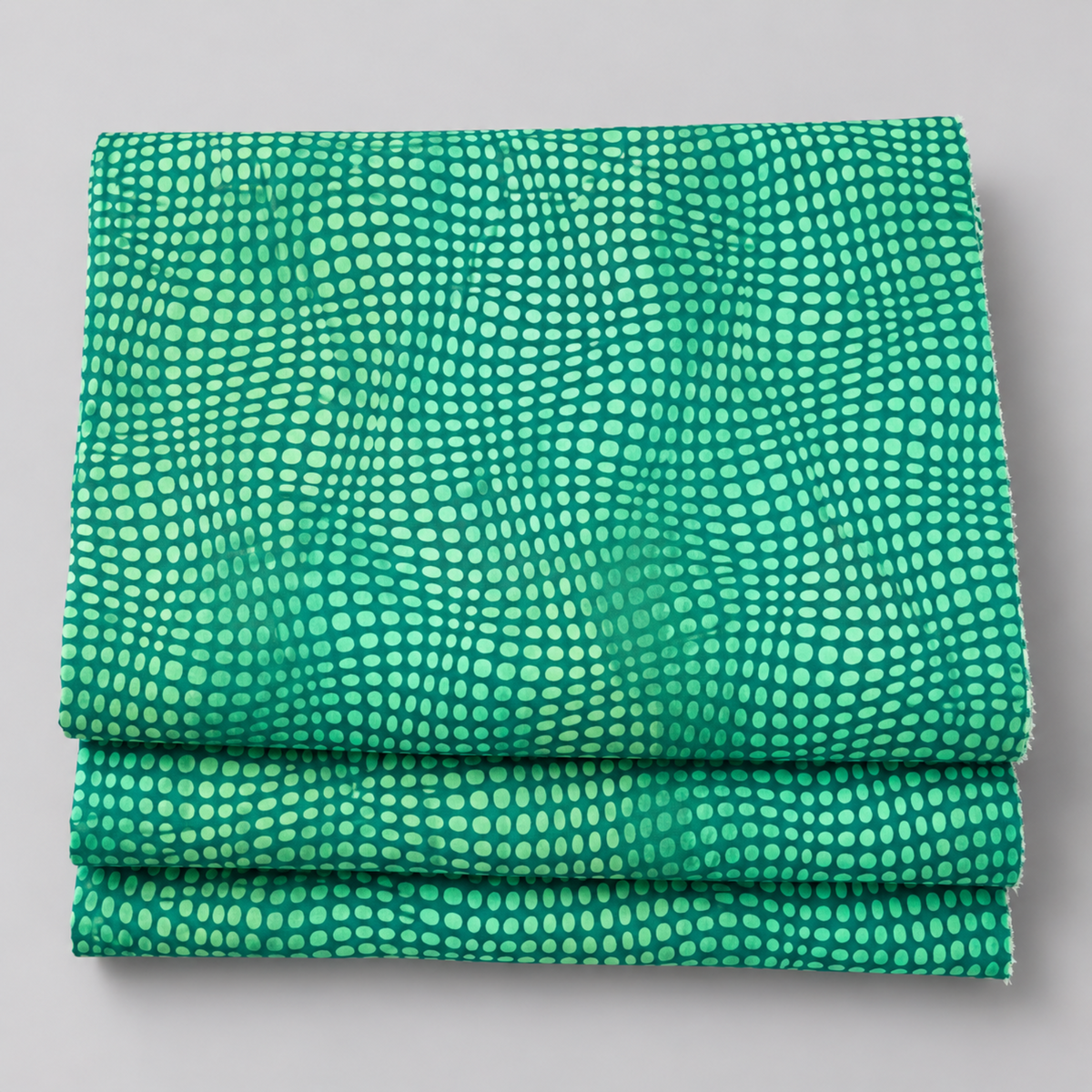 Folded stack of Impressions Mint Dots quilting fabric showing the repeating dot pattern