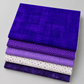 Interwoven Blueberry fabric layered with coordinating purple and cream quilting fabrics.
