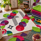 Interwoven Spring Grass Fabric by Jason Yenter for In The Beginning Fabrics featured in curved circle blocks and as the top of a coordinating fabric stack on a sewing table — paired with hot pink, teal, purple, and red prints in a Moon Dance quilt top on a white background with gray sashing. Rotary cutter, cutting mat, wonder clips, and "Stitch Gather Create Joy" mug in the scene. Quilts shown for inspiration feature the Moon Dance Quilt Pattern by Sew Kind of Wonderful — available at IraRobi Quilts.