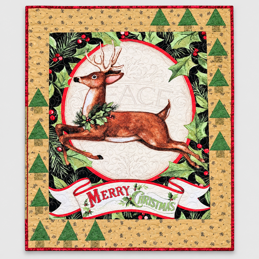 Handmade Christmas quilt featuring a leaping brown reindeer, holly and pine greenery, a cream “Peace” center, and a “Merry Christmas” banner, framed by a gold border with green trees and red binding.