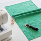Impressions Mint Dots quilting cotton styled on cutting mat with quilting tools – lifestyle shot for quilters