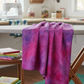Impressions Magenta Dots quilting cotton in magenta and purple tones draped in sewing room with cutting mat and tools