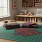 Impressions Multi Dark Raindrops quilting cotton styled on cutting mat with quilting tools – lifestyle shot for quilters