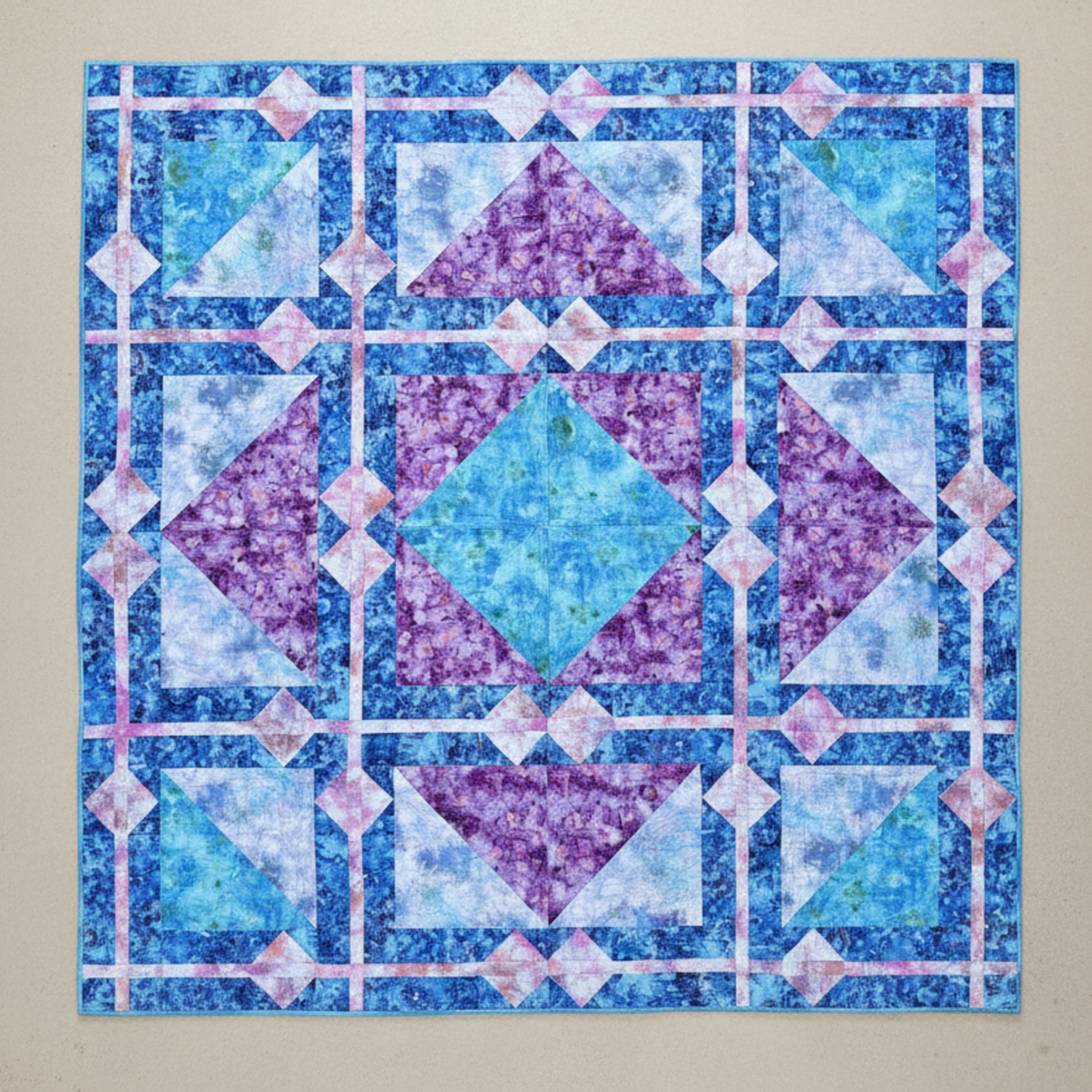 Fire & Ice handmade geometric quilt laid flat with blue and violet batik fabrics