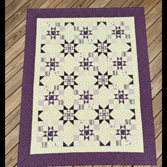 Handmade I Love Purple quilt with star blocks laid flat outdoors
