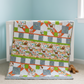 Children's quilt with animal pattern on a crib against a light blue wall.