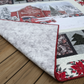 Tree Farm handmade winter quilt showing front snowy barn scene with folded corner revealing soft neutral backing.