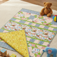 Children's quilt with animal patterns on a floor with toys around