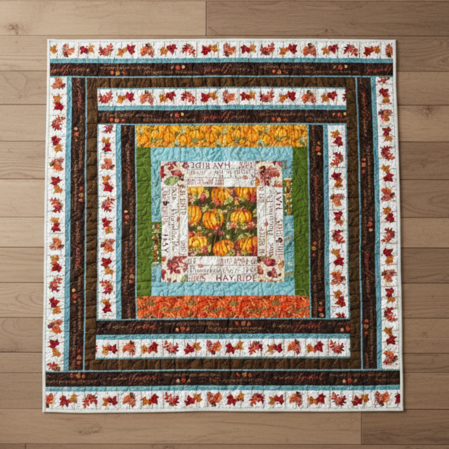 Handmade fall throw quilt with pumpkin centerpiece, autumn leaves, harvest words, and rich brown, orange, and cream borders.