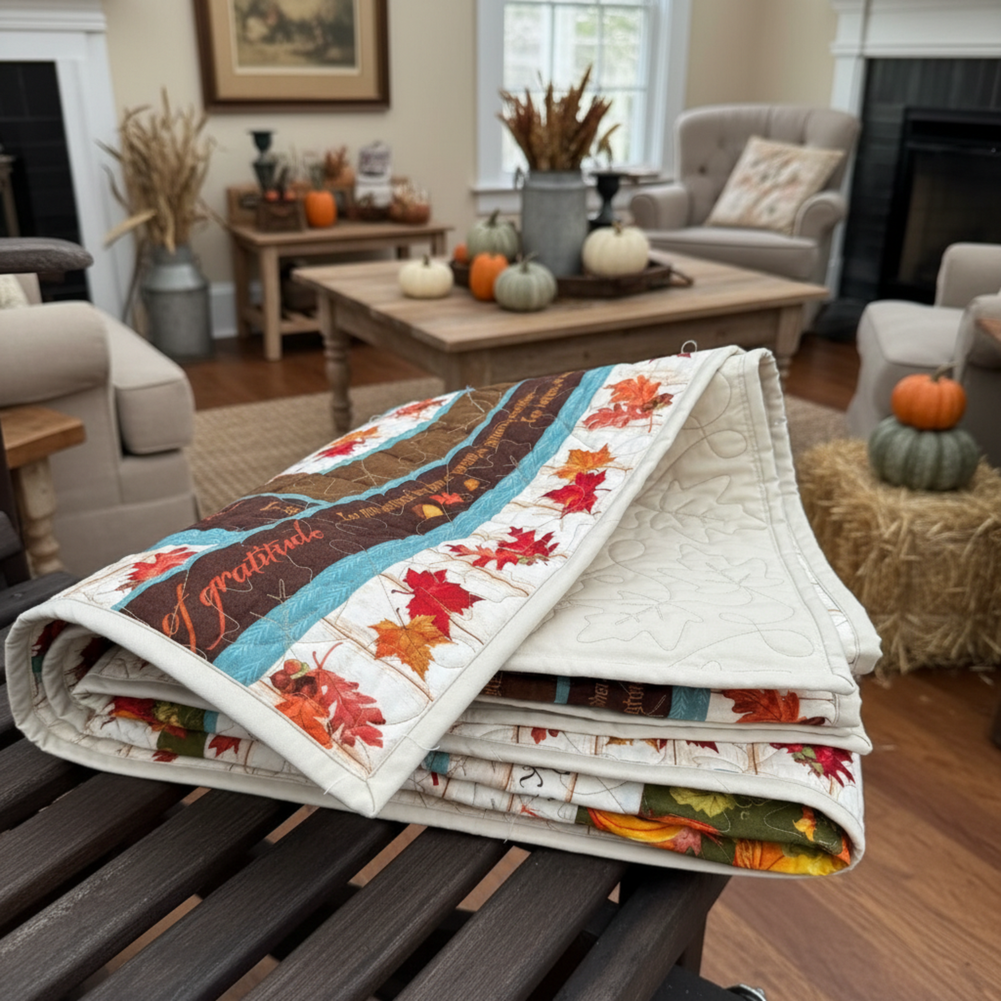 Fall-themed quilt on a table in a cozy living room.