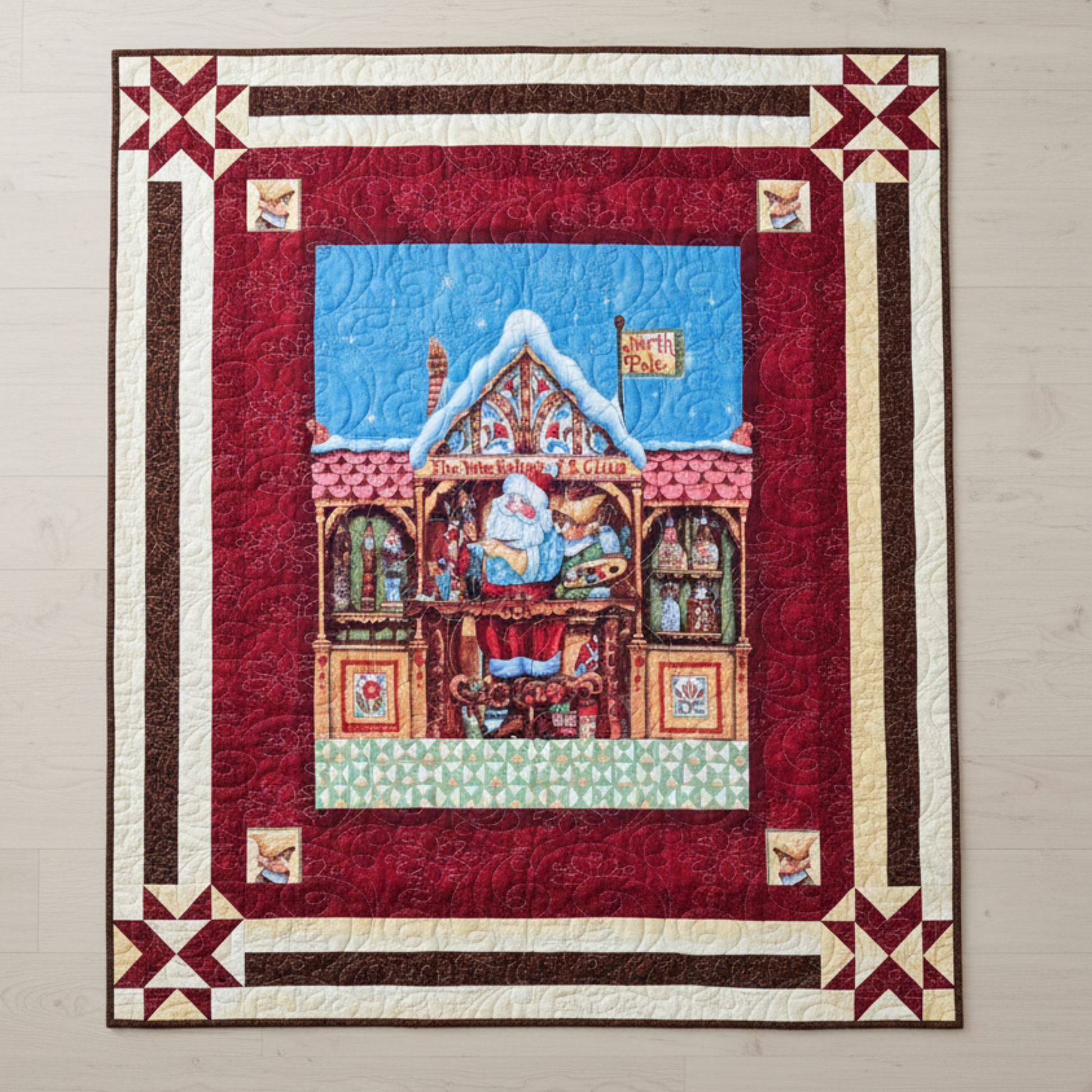 Handmade Christmas quilt featuring Santa in his North Pole workshop, framed by rich red and cream borders with star accents.”