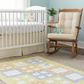 Nursery room with crib, rocking chair, and quilt on the floor.