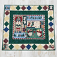 Colorful quilt with geometric patterns and Christmas-themed scenes on a wooden floor.