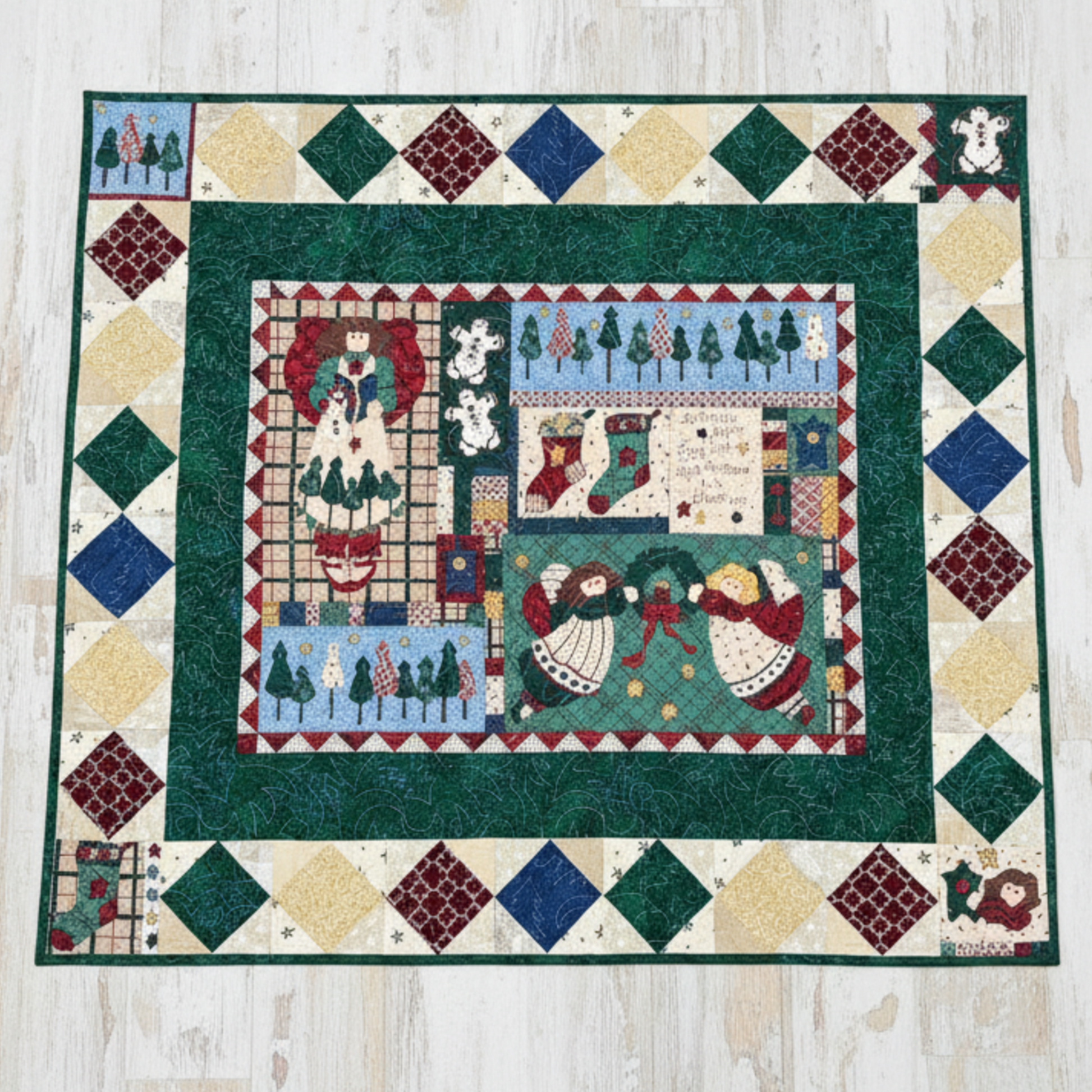 Colorful quilt with geometric patterns and Christmas-themed scenes on a wooden floor.