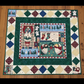 Quilt with Christmas-themed design on a wooden floor