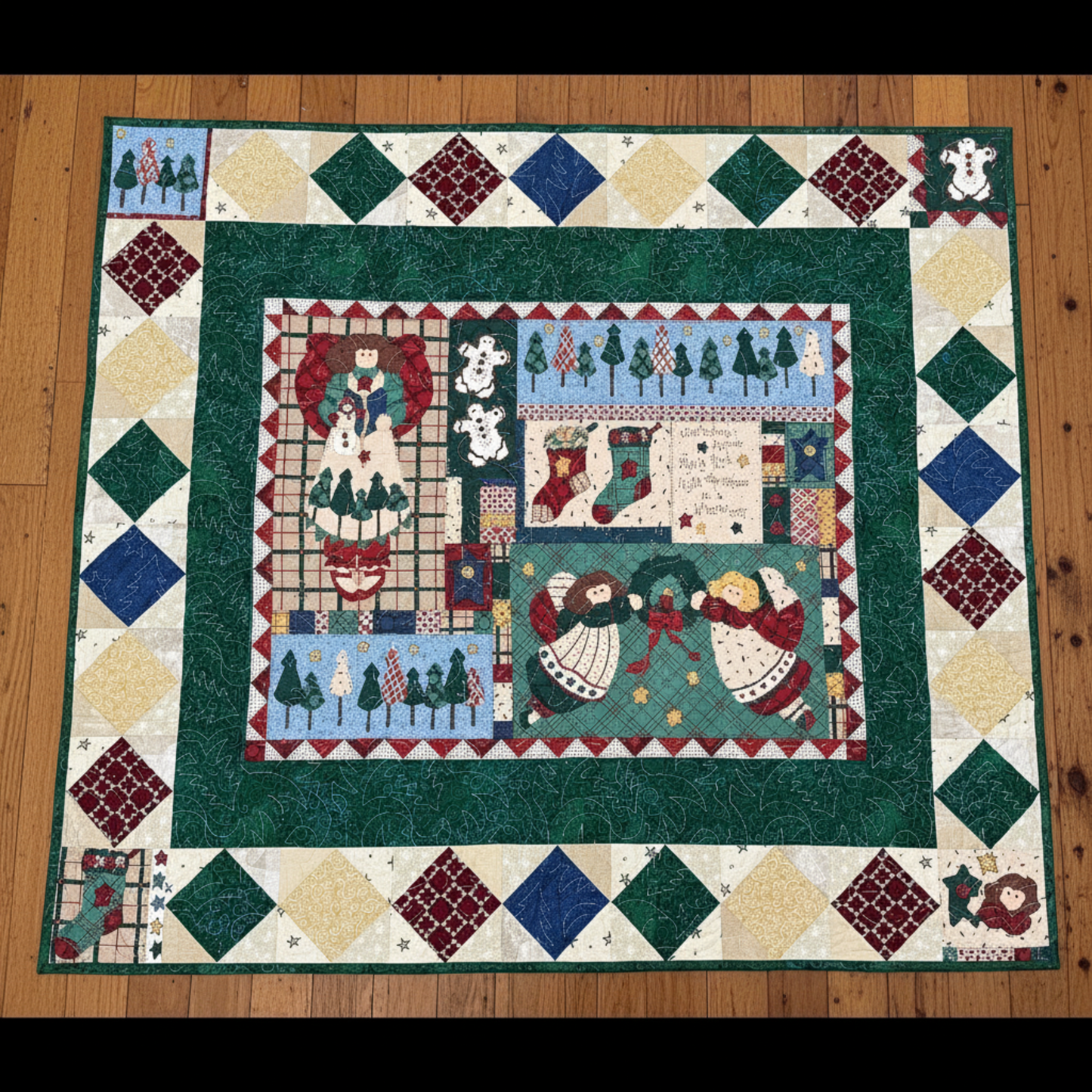 Quilt with Christmas-themed design on a wooden floor