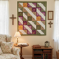 Meaningful handmade log cabin quilt with faith-inspired words in soft green, purple, gold, and cream.