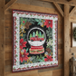 Decorative quilt with Christmas design featuring a snow globe and poinsettias on a wooden wall.