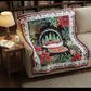 Decorative Christmas-themed quilt draped over a couch in a cozy living room.