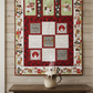 Handmade winter throw quilt with cocoa-themed panels, hot chocolate mugs, marshmallows, and festive red and green borders.