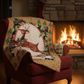 Red armchair with a Christmas-themed quilt draped over it, in front of a fireplace.