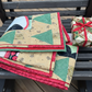 Stack of quilted fabric blocks with a Christmas theme on a wooden surface.